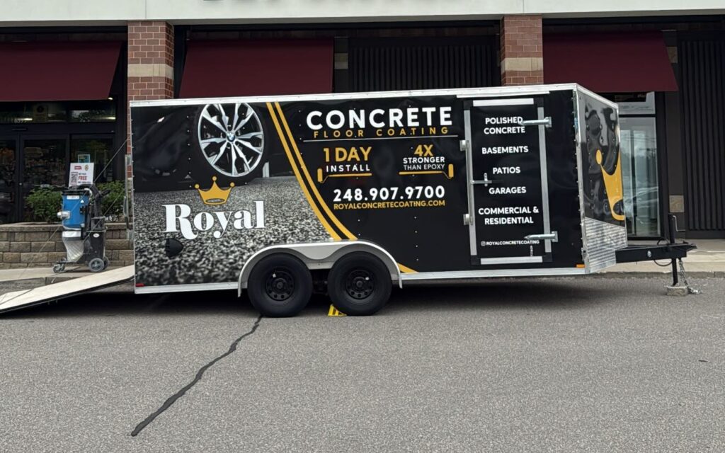 A trailer advertising concrete coating is parked outside Premier Pet Supply, showcasing flooring services. No persons are visible in the image.
